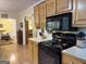 Well-equipped kitchen with wood cabinets, and black appliances, designed for efficient meal preparation at 712 Honeysuckle Ln, Temple, GA 30179