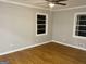 Spacious bedroom showcasing hardwood floors, neutral paint, and plenty of natural light from two windows at 1607 Hillview Ave, Jonesboro, GA 30236