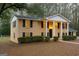 Charming brick home featuring a symmetrical facade, black shutters, and a classic white columned porch at 1607 Hillview Ave, Jonesboro, GA 30236