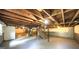 Spacious unfinished basement with exposed beams, concrete floor, and staircase at 292 S Prospect Ave, Waco, GA 30182