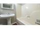 Bright bathroom with a pedestal sink and a bathtub featuring updated fixtures at 292 S Prospect Ave, Waco, GA 30182