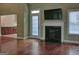 Open living area with hardwood floors, a modern fireplace, and access to the adjacent kitchen at 834 Chalet Hills, Mcdonough, GA 30253