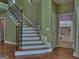 Elegant staircase with hardwood steps and wrought iron railings, leading to upper level and laundry room at 834 Chalet Hills, Mcdonough, GA 30253
