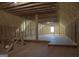 Unfinished attic space featuring exposed wooden beams, insulation, and a small window at 368 Ginger Cake Rd, Fayetteville, GA 30214