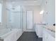 Bathroom featuring a soaking tub with a glass shower, a vanity with drawers and tiled floors at 368 Ginger Cake Rd, Fayetteville, GA 30214