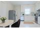 All-white kitchen features stainless steel appliances, white cabinetry, a dining area and adjacent laundry area at 368 Ginger Cake Rd, Fayetteville, GA 30214