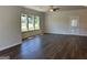 Living room featuring dark hardwood floors, three windows for natural light, and neutral wall color at 3706 Cheswoilde Ave # 96, Powder Springs, GA 30127