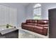 Bedroom with a brown leather couch and large window at 702 Brambling Way, Stockbridge, GA 30281