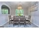 Dining room features modern chandelier and table, and an arched passthrough to the next room at 702 Brambling Way, Stockbridge, GA 30281