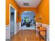 Foyer with gleaming hardwood floors and orange walls, transitioning to the living room with an arched doorway at 702 Brambling Way, Stockbridge, GA 30281