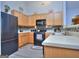 Well-equipped kitchen with wood cabinets, black appliances, and a tiled backsplash, providing a functional space at 702 Brambling Way, Stockbridge, GA 30281