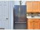 Stainless steel refrigerator next to wood cabinets and mosaic tile backsplash in the kitchen at 702 Brambling Way, Stockbridge, GA 30281