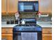 Close-up of the kitchen range, showing a mosaic backsplash, exhaust fan, and tea kettle at 702 Brambling Way, Stockbridge, GA 30281