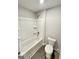 Bathroom with white bathtub and shower, toilet, and dark gray tile floors at 376 Layfield Dr, Jonesboro, GA 30238