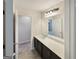 Bathroom features a dark vanity, broad mirror, and modern lighting fixtures at 376 Layfield Dr, Jonesboro, GA 30238