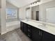 Bathroom featuring double sinks, tiled floor, soaking tub with tile surround, and natural light at 376 Layfield Dr, Jonesboro, GA 30238