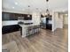 Open kitchen with dark cabinets, granite island with seating, stainless steel appliances, and wood floors at 376 Layfield Dr, Jonesboro, GA 30238