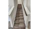Carpeted staircase with white risers and a wooden handrail leading to the upper level of the home at 376 Layfield Dr, Jonesboro, GA 30238
