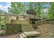 Spacious backyard deck with multiple stairways and lush, mature trees at 1213 Laurel Cliff Se Dr, Smyrna, GA 30082