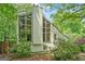 Exterior of the house surrounded by lush greenery and large windows at 1213 Laurel Cliff Se Dr, Smyrna, GA 30082