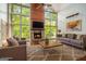 Sun-drenched living room features floor-to-ceiling windows, a stone fireplace, and hardwood floors at 1213 Laurel Cliff Se Dr, Smyrna, GA 30082