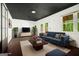 Bright living room features a dark ceiling, a plush blue sofa, and large windows showcasing outdoor views at 1213 Laurel Cliff Se Dr, Smyrna, GA 30082