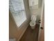 Small half bath/powder room with hardwood flooring, window and a toilet at 140 Clover Valley Dr, Covington, GA 30016
