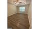 A bright bedroom featuring a window, ceiling fan, and wood-look flooring at 140 Clover Valley Dr, Covington, GA 30016