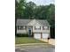 Inviting two-story home with a well-maintained lawn, dual garage doors, and classic architectural details at 140 Clover Valley Dr, Covington, GA 30016