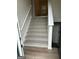 Carpeted stairs with a white railing lead to the upper level at 140 Clover Valley Dr, Covington, GA 30016