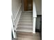 Carpeted stairs with a white railing lead to the upper level at 140 Clover Valley Dr, Covington, GA 30016