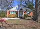 Charming brick home features a front porch, mature trees, and landscaped front yard at 3464 Wren Rd, Decatur, GA 30032