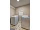 Bright laundry room with tiled floors, a white brick wall, and modern, front-loading washer and dryer at 3464 Wren Rd, Decatur, GA 30032