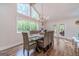 Beautifully staged dining room with a lovely chandelier and views of the wooded outdoors at 4100 Springlake Cir, Buford, GA 30519