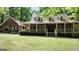 Traditional brick home with a long covered porch and dormer windows at 31 Butler Bridge Dr, Mcdonough, GA 30252