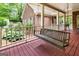 Back porch with wooded views features hanging bench for comfortable seating at 31 Butler Bridge Dr, Mcdonough, GA 30252