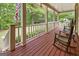 Back porch with American flag and wooded views features rocking chairs for outdoor enjoyment at 31 Butler Bridge Dr, Mcdonough, GA 30252