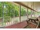 View of covered back porch featuring a wooden swing and wooded view of the backyard at 31 Butler Bridge Dr, Mcdonough, GA 30252