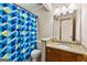 Cozy bathroom featuring a single sink vanity with granite counters and a shower/tub with blue patterned shower curtain at 155 Grandview Trce, Fayetteville, GA 30215