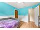 Bedroom with aqua walls and white wainscoting, featuring vinyl floors, a small window, and a ceiling fan at 155 Grandview Trce, Fayetteville, GA 30215