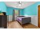 Bedroom with aqua walls and white wainscoting, featuring vinyl floors, a small window, and a ceiling fan at 155 Grandview Trce, Fayetteville, GA 30215