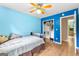 Well-lit blue bedroom with fan, window, closet, and wood floors provides a serene living space at 155 Grandview Trce, Fayetteville, GA 30215