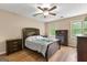 Spacious bedroom featuring wood flooring, two windows and a ceiling fan, complemented by dark wood furniture at 155 Grandview Trce, Fayetteville, GA 30215