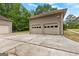 Spacious two-car garage with a concrete driveway and surrounded by lush trees and greenery at 155 Grandview Trce, Fayetteville, GA 30215