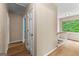 Bright hallway with wood floors, white trim, and a window overlooking lush greenery, offering a warm welcome at 155 Grandview Trce, Fayetteville, GA 30215