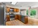 Kitchen with stainless steel appliances, granite countertops, wood cabinets, and natural lighting at 155 Grandview Trce, Fayetteville, GA 30215