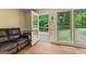 Inviting living room with wood floors, a leather sofa, and views of the backyard deck and trees at 155 Grandview Trce, Fayetteville, GA 30215