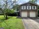 Charming two-story home features a lush front yard, a two-car garage, and classic architectural details at 4457 Huntshire Dr, Stone Mountain, GA 30083