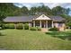 Well-maintained single-story brick home with manicured lawn, mature landscaping, and a covered front porch at 109 Old Virginia Cir, Jonesboro, GA 30236
