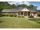 Inviting front lawn of a single-story brick home with a covered porch, manicured lawn, and mature trees at 109 Old Virginia Cir, Jonesboro, GA 30236